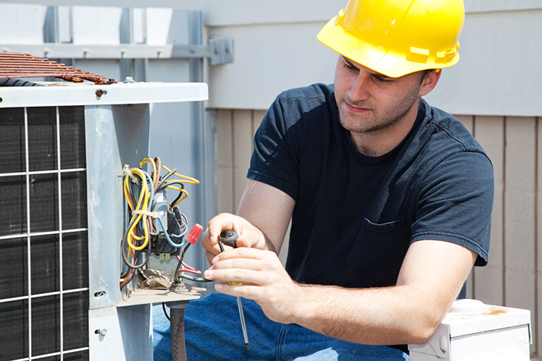 Man Working on Air Conditioning Unit | Air Conditioning, Air Conditioning Repairs, Air Conditioning Installation, and More in Southampton, NY and the Surrounding Areas